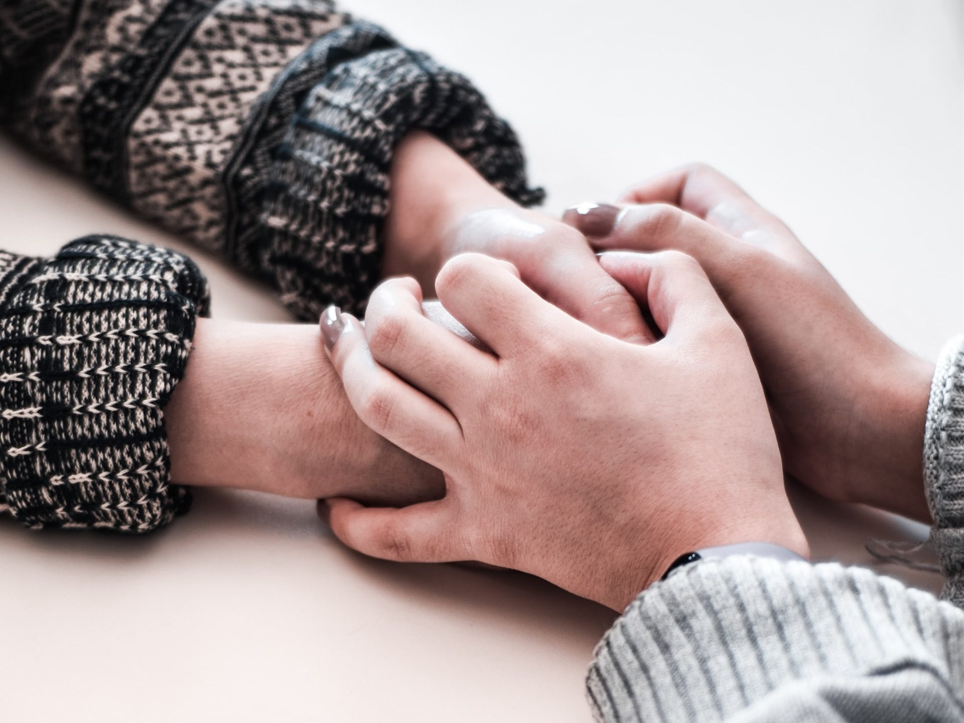 person in gray long sleeve shirt holding persons hand